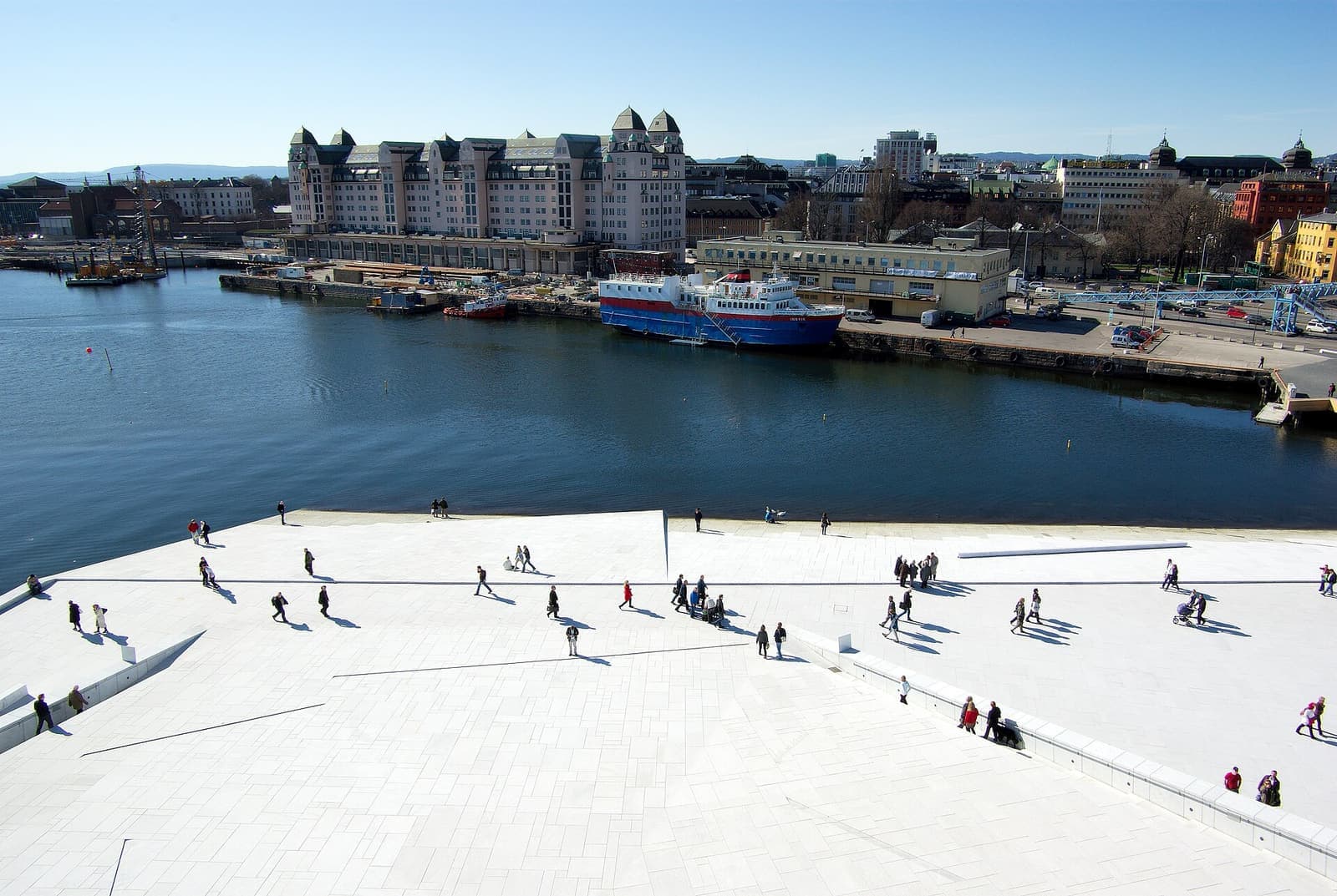 The sloping white roof of the Oslo opera house beside the fjord